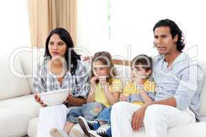 Concentrated family watching TV on sofa