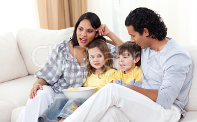 Jollyfamily watching TV on sofa