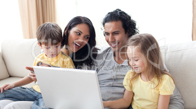 Happy family using laptop on sofa