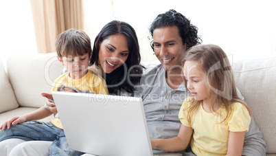 Affectionate parents using laptop with their children