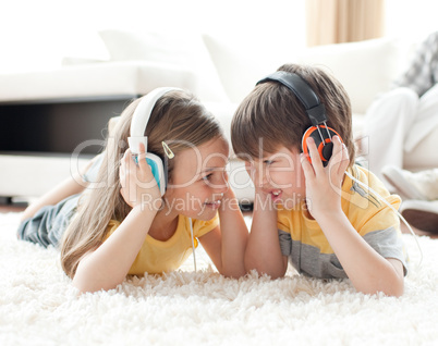 Siblings playing on the floor with headphones