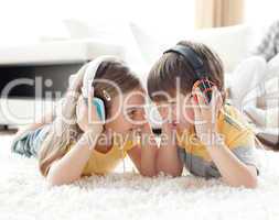 Siblings playing on the floor with headphones