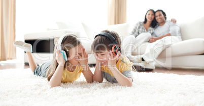 Laughing children listening music with headphones