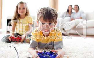 Cute little boy playing video game with his sister