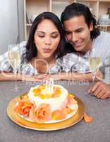 Pretty woman blowing up candles with her husband for her birthda