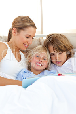 Pretty mother and her children reading book