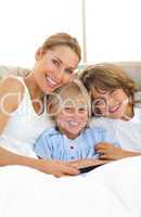 Attractive mother and her children reading book