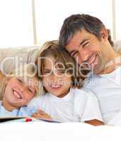 Smiling father and his children reading book