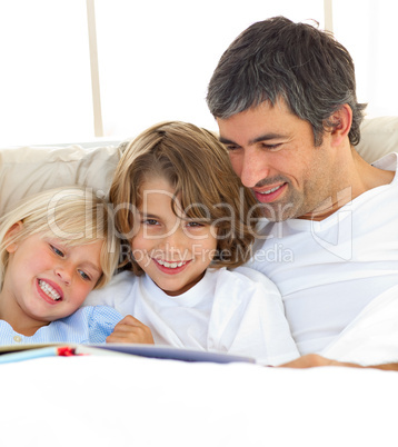 Close-up of father and his children reading book