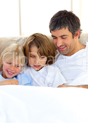 Attentive father and his children reading book