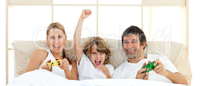 Smiling little boy playing video game with his family