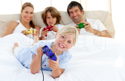 Little blond girl playing video game with her family