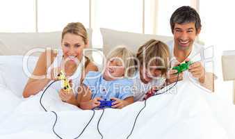 Adorable family playing video game in the bedroom