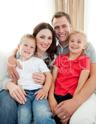 Close-up of adorable family sitting on sofa