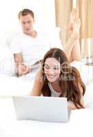 Beautiful woman with her husband working at a laptop