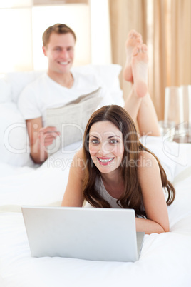 Pretty woman with her husband working at a laptop