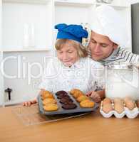 Attentive father and his son presenting their muffins