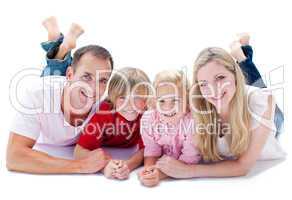 Joyful family lying on the floor