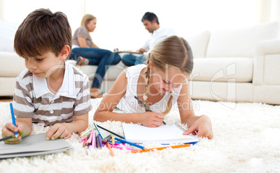 Cute siblings drawing lying on the floor