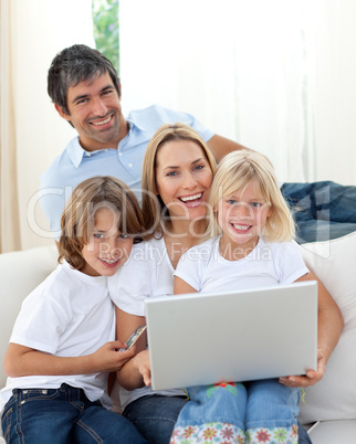 Cute children with their parents using a laptop