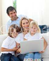 Cute children with their parents using a laptop