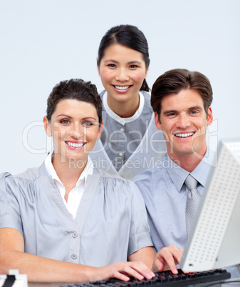 Portrait of three colleagues working at a computer