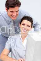 Smiling business woman and her colleage working at a computer