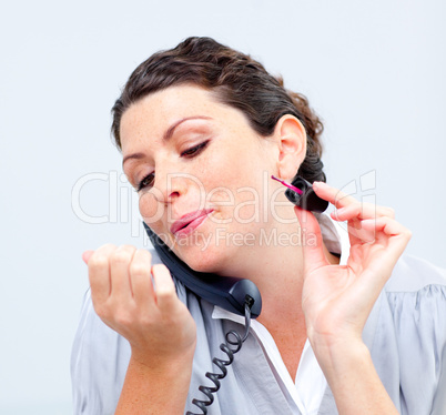 Close-up of businesswoman on phone painting her nails