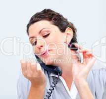 Close-up of businesswoman on phone painting her nails