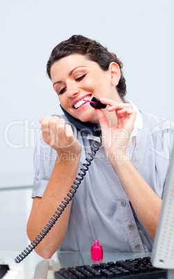 Smiling woman on phone painting her nails