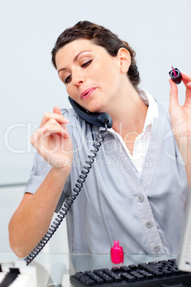 Talkative woman on phone painting her nails