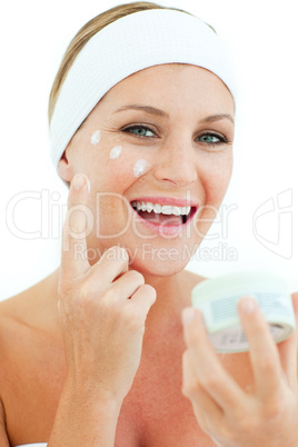 Caucasian woman putting cosmetic cream