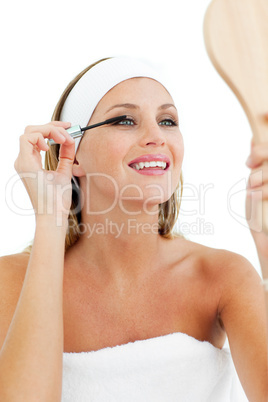 Smiling woman putting mascara