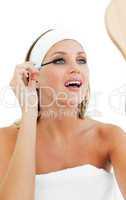 Blond woman putting mascara