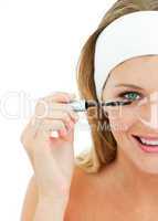 Young woman putting mascara