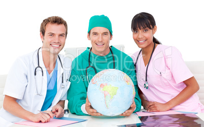 Joyful medical team looking at terrestrial globe
