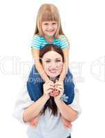 Smiling brunette mother giving her daughter piggyback ride