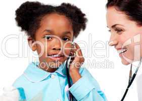 Adorable little girl and her doctor playing with a stethoscope