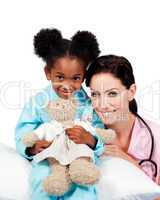 Cute little girl with her doctor smiling at the camera