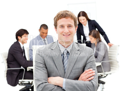 Assertive male executive with folded arms sitting in front of hi