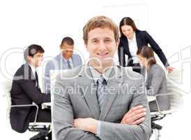 Assertive male executive with folded arms sitting in front of hi