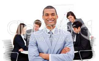 Ethnic businessman sitting in front of his team