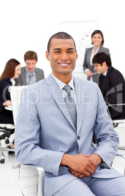 Afro-american businessman sitting in front of his colleagues