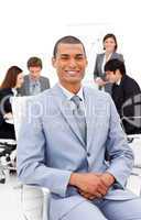 Afro-american businessman sitting in front of his colleagues