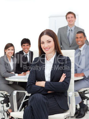 Smiling businesswoman sitting in front of her team