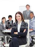 Smiling businesswoman sitting in front of her team