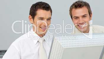 Two businessmen working together at a computer