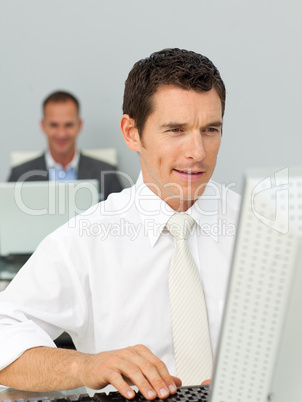 Smiling businessman working at his computer