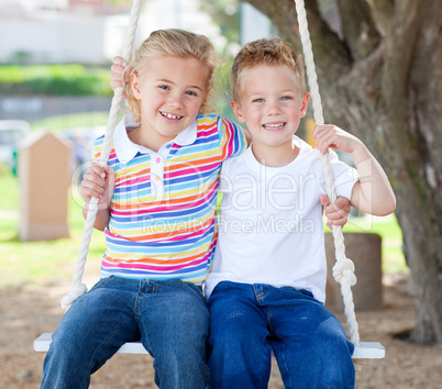 Cute siblings swinging