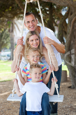 Cheerful family swinging